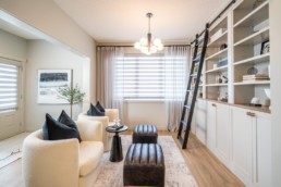 Pacesetter Homes Calypso showhome in Jensen Lakes St. Albert. Lifestyle room with white chairs and decoration ladder to interior designed modern shelves and large windows.