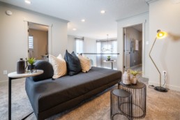 Pacesetter homes showhome loft with grey couches and spacious living area in Jensen Lakes.